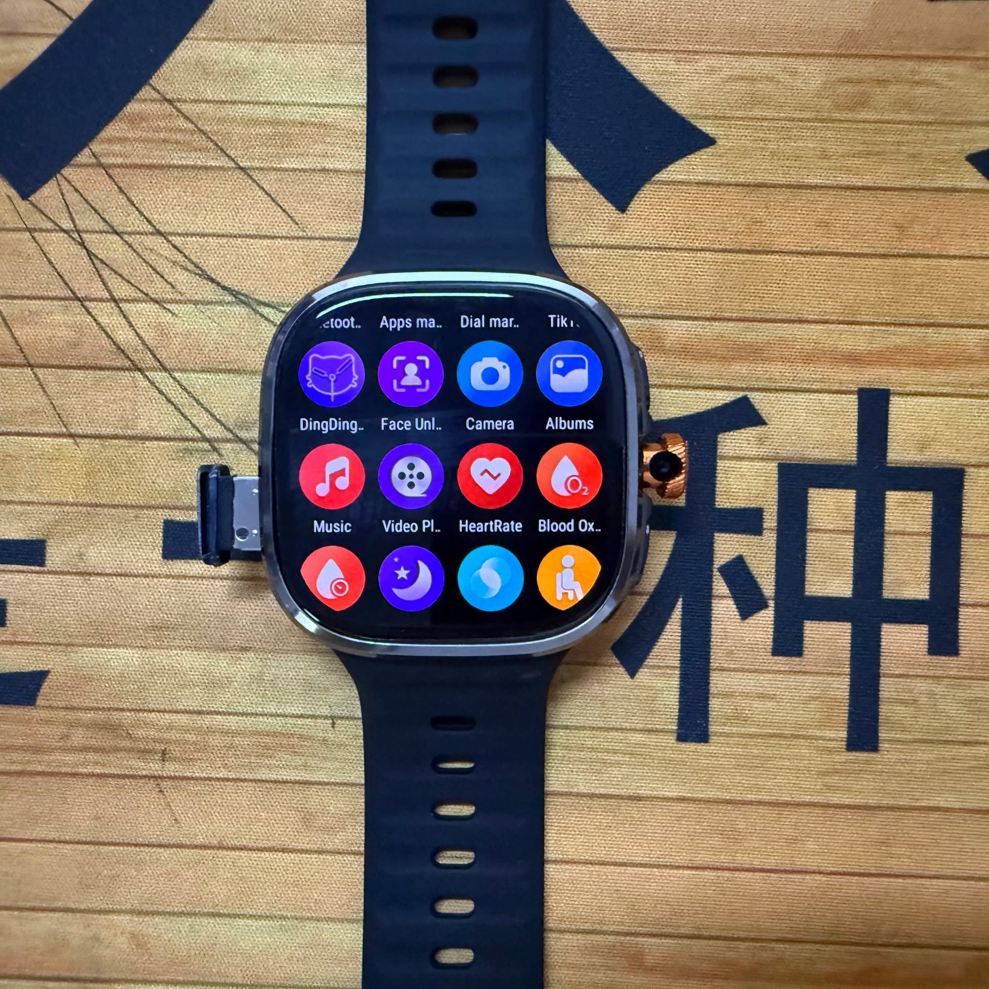 Smartwatch with app icons on a wooden surface